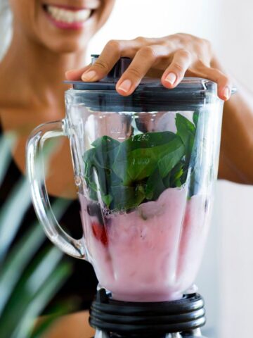 A woman blending a smoothie.